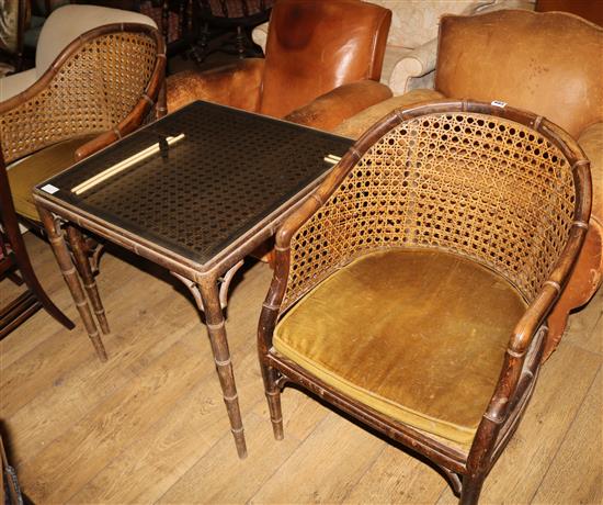 A pair of caned beech tub chairs with simulated bamboo moulding a matching glass top table, W.64cm H.67cm